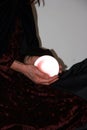 Hands cradling a glowing crystal ball